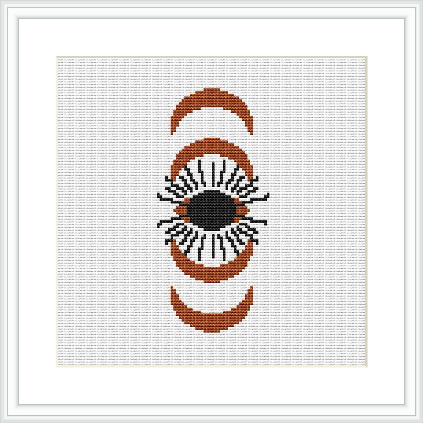 A cross stitch pattern featuring an eye framed by two crescent shapes on a white canvas. The design is composed of brown, beige, black, and orange colors.