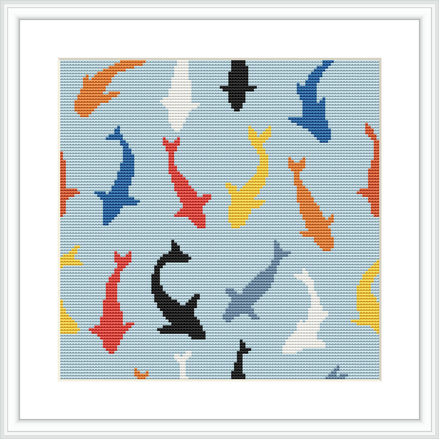 The image shows a cross stitch embroidery pattern of various colored sharks - red, blue, yellow, black, and white, distributed over a light blue background that implies an underwater environment.