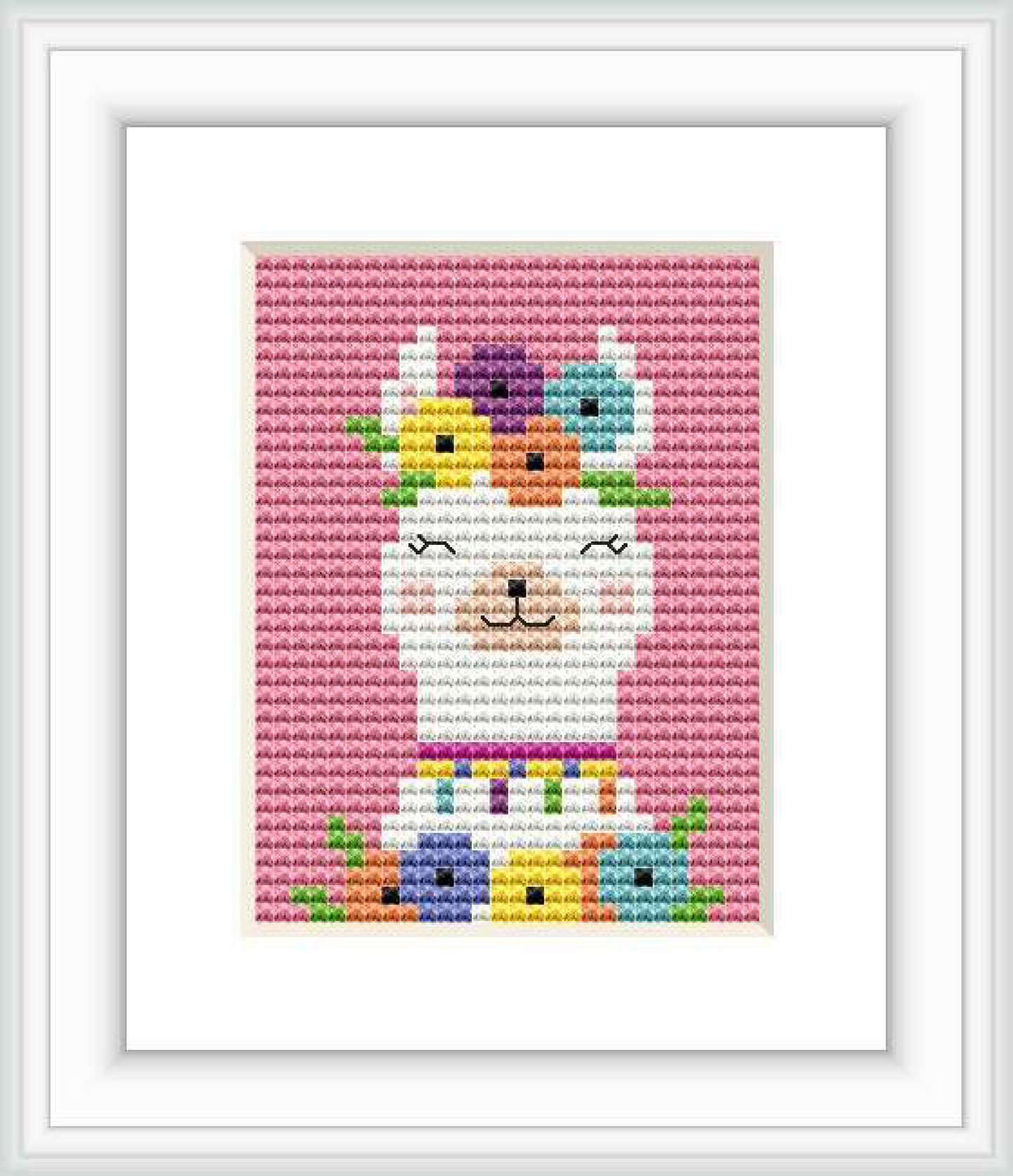 The image shows a framed cross stitch pattern with a colorful, stylized depiction of a llama. The llama is created with an array of pastel and bright colors, arranged in sections throughout its body, with a white background. The pattern is enclosed within a white square frame against a light-colored backdrop.