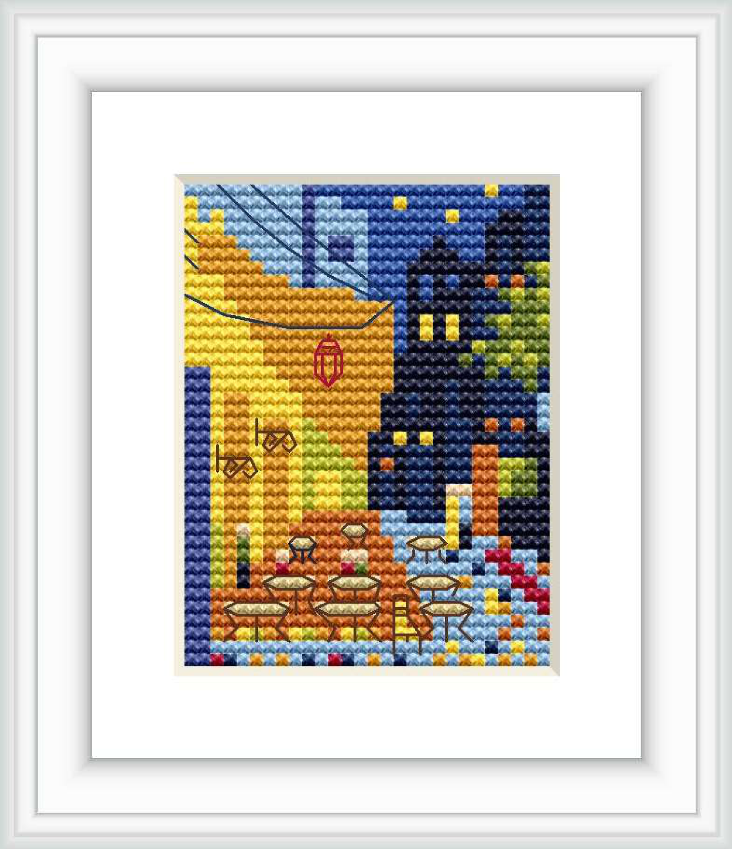 The cross stitch pattern depicts a cozy cafe terrace with several tables and chairs, set against a backdrop of buildings and a night sky scattered with stars.