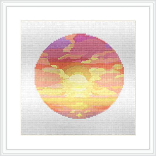 The image depicts a circular cross stitch pattern representing a sunset. The sunset is composed of a gradient of colors ranging from purples at the top, through pinks, to yellows and oranges at the bottom. Cloud-like patterns are stitched in white and lighter hues, set against the vibrant colors of the sky.