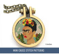 The cross stitch features a stylized portrait reminiscent of Frida Kahlo, with floral elements in her hair. The design lies within a circular frame with a bronze chain attached.