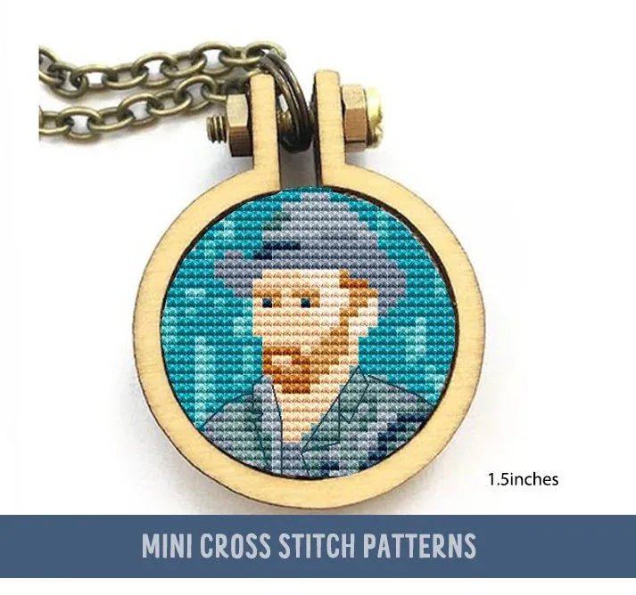 A cross stitch pattern depicting a stylized version of Van Gogh's self-portrait, framed in a small circular embroidery hoop with a chain attached, suggesting it's used as a pendant.