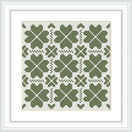 The image presents a framed cross stitch pattern consisting of multiple green clover motifs arranged in a symmetrical grid on a white background.