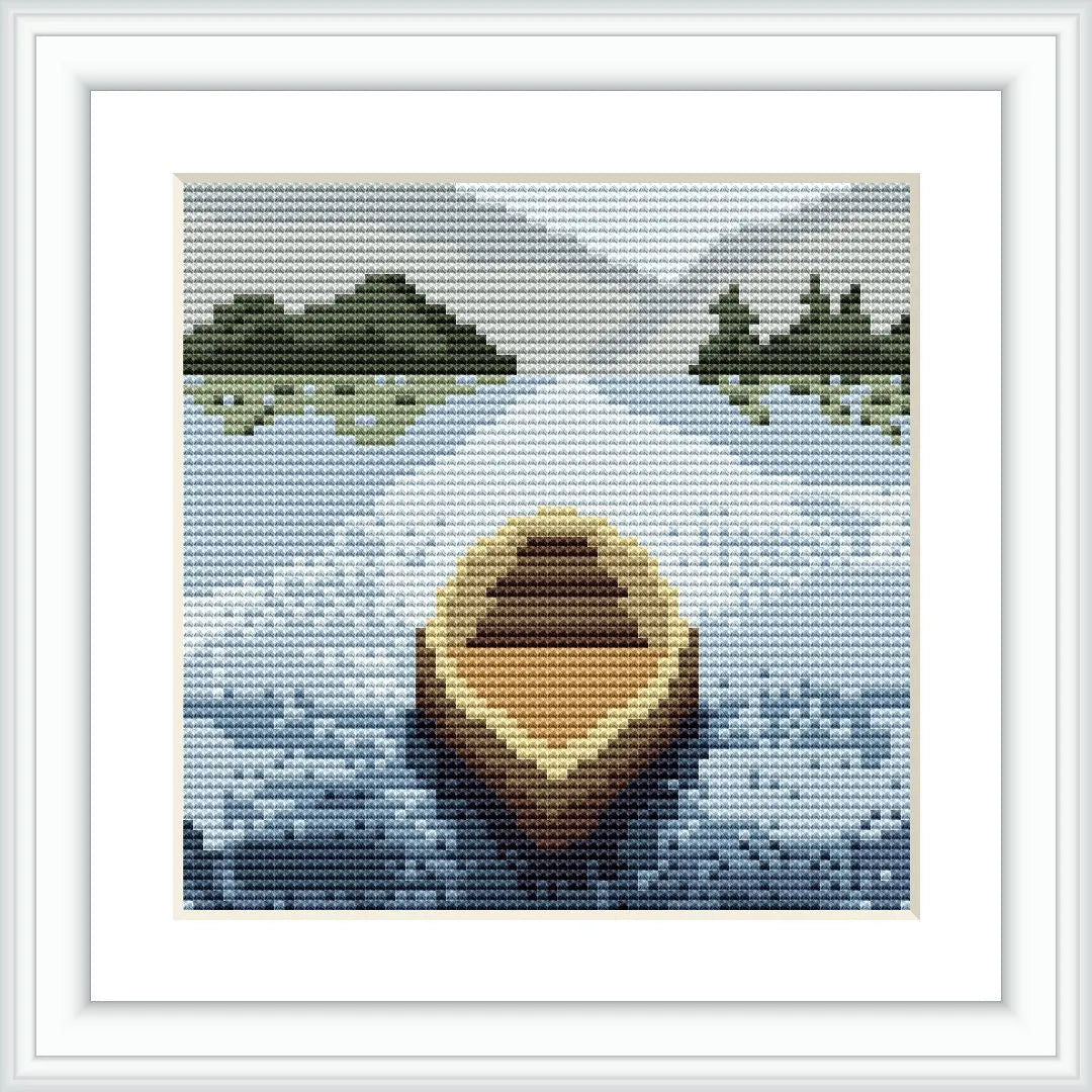 The image depicts a cross stitch pattern of a serene lake scene, with a lone wooden boat in the foreground and groups of trees on both sides of the lake in the background. The sky is depicted with shades of blue and white, suggesting a possibly cloudy day.