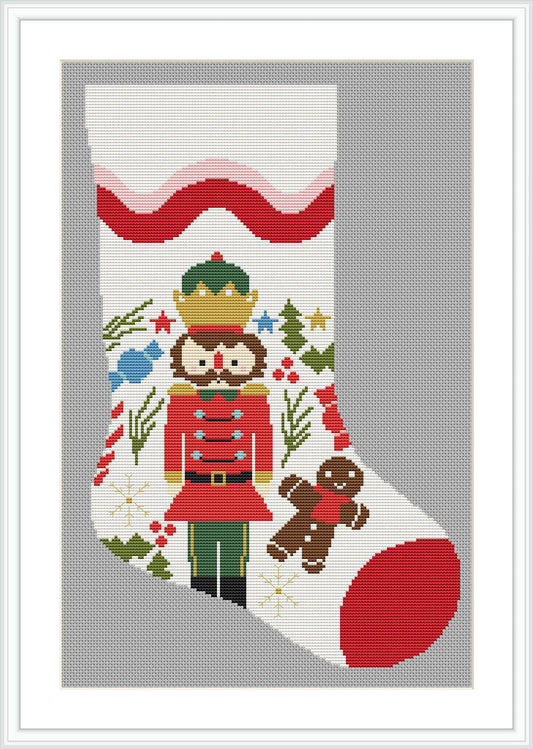 The image depicts a Christmas stocking adorned with a nutcracker soldier, a gingerbread man, colorful stars, holly leaves, and berries. The stocking features red accents on the toe and cuff, with a background of festive patterns.