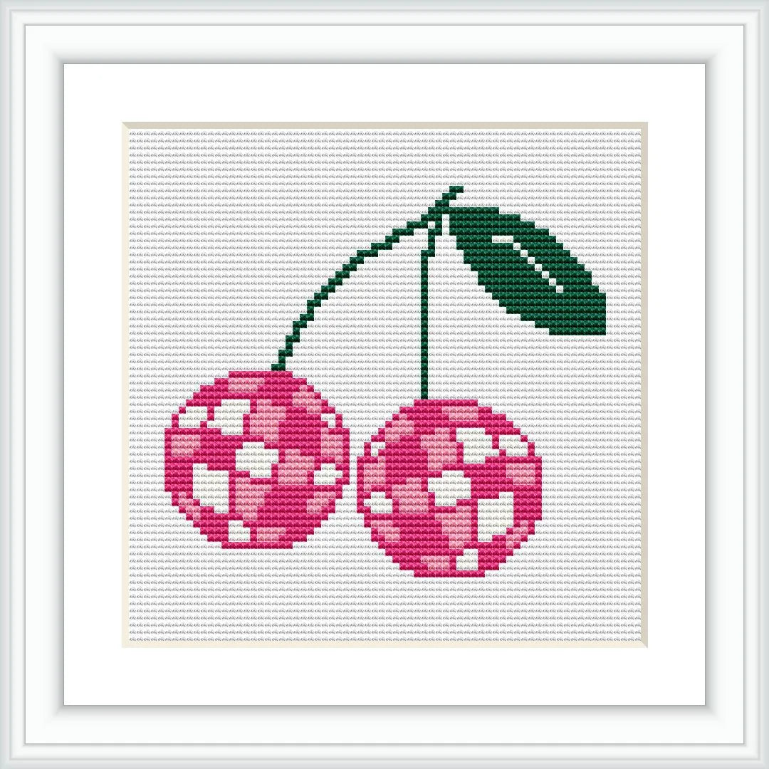 The image depicts a cross stitch pattern of two cherries with a geometric, disco-like pattern. The cherries are connected by green stems and a single green leaf, all placed on a white background framed by a minimalist white border.