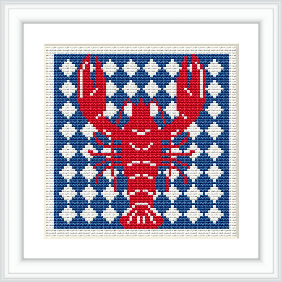 The image features a cross stitch design of a red lobster prominently displayed against a background of alternating navy blue and white geometric patterns. The design is framed with a simple white border.