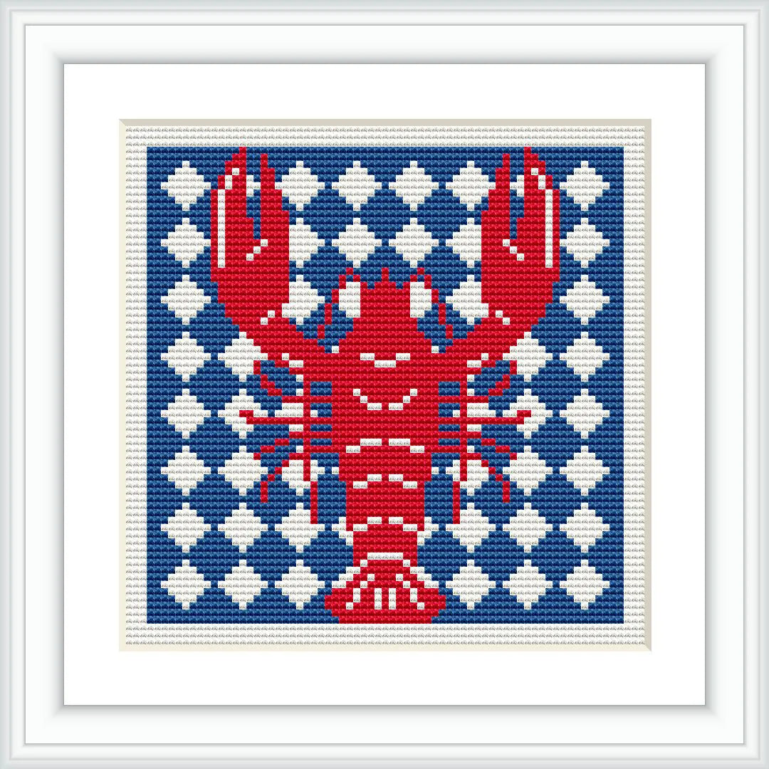 The image features a cross stitch design of a red lobster prominently displayed against a background of alternating navy blue and white geometric patterns. The design is framed with a simple white border.