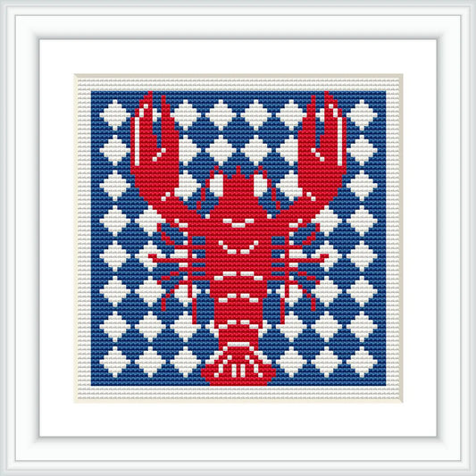 The image features a cross stitch design of a red lobster prominently displayed against a background of alternating navy blue and white geometric patterns. The design is framed with a simple white border.