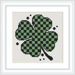 A symmetrical pattern of a four-leaf clover with a checkerboard design in the leaves, surrounded by a few additional small squares as accent.