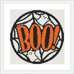 The image features a round cross stitch design with the word 'BOO!' in large, bold orange letters. The background consists of intricate spiderwebs and playful white ghost figures.