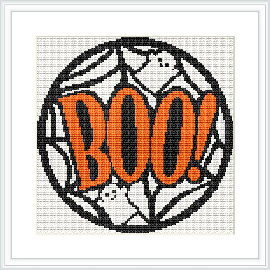 The image features a round cross stitch design with the word 'BOO!' in large, bold orange letters. The background consists of intricate spiderwebs and playful white ghost figures.