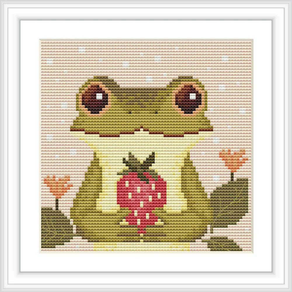 The image features a green frog holding a red strawberry at the center. It is surrounded by two small orange flowers with green leaves. The background is light pink with small white dots.