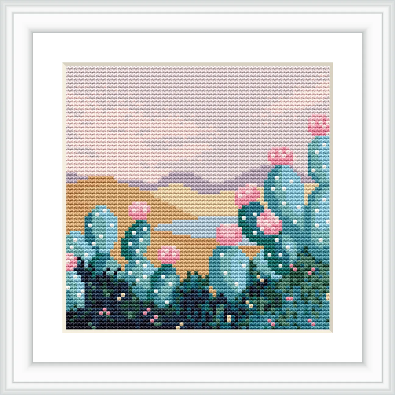 The image depicts a group of green cacti with pink flowers, set against a backdrop of desert mountains and a pale blue sky.