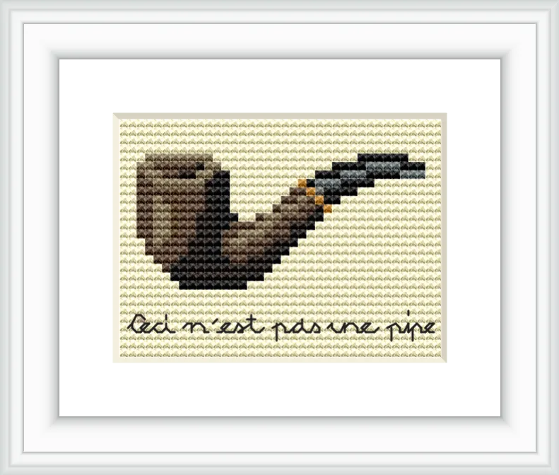 The image features a simple cross stitch of a brown and black pipe with a handwritten text underneath that reads 'Ceci n'est pas une pipe'. The design is centered on a cream background.