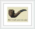 The image features a simple cross stitch of a brown and black pipe with a handwritten text underneath that reads 'Ceci n'est pas une pipe'. The design is centered on a cream background.