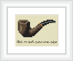 The image features a simple cross stitch of a brown and black pipe with a handwritten text underneath that reads 'Ceci n'est pas une pipe'. The design is centered on a cream background.