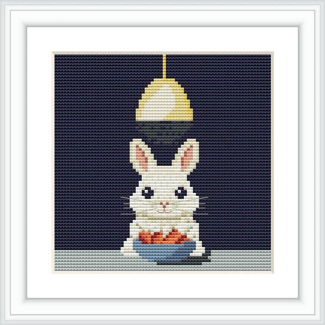 A white bunny with pink ears sitting below a hanging light. The bunny is holding a blue bowl filled with orange carrots on a light-colored surface.