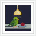 A green bird is perched on a surface next to a red apple, illuminated by a yellow hanging lamp against a dark blue background.