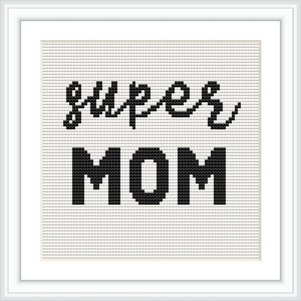 The image displays a cross stitch pattern with the words 'super mom' in black thread on a white background, framed elegantly.