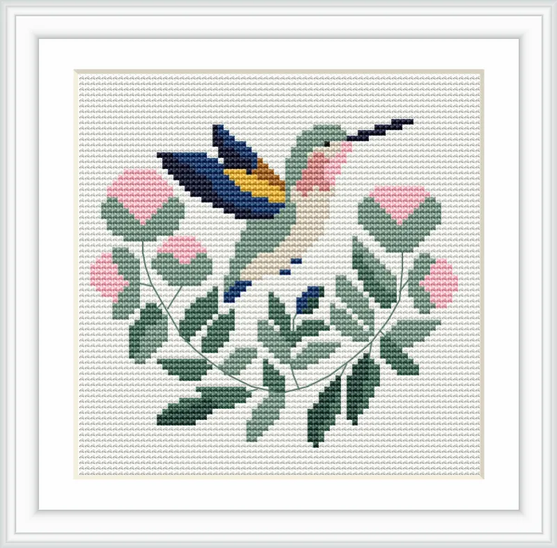 A beautifully detailed cross stitch depicts a hummingbird in mid-flight among pink flowers and leafy branches.