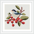 A small bird is sitting on a branch, surrounded by bright red berries and green leaves. The bird has a black head, a white body, and blue wings. The setting appears serene and natural.