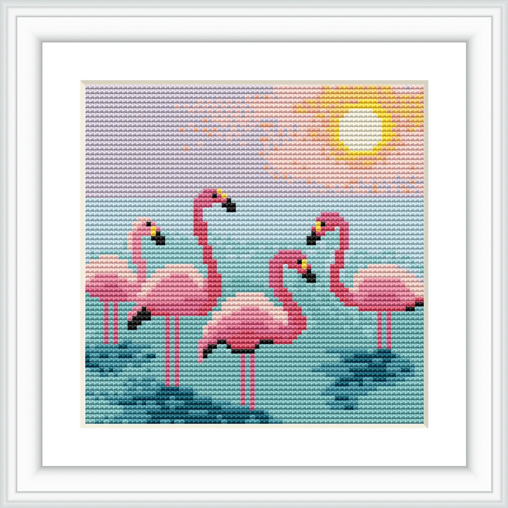 The image features five pink flamingos standing in calm water. The background is a serene sunset with a bright sun, soft clouds, and a tranquil sky.
