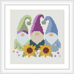 The image depicts three gnomes standing side by side. Each gnome has a differently colored hat: green, purple, and blue. Behind the gnomes, there are two large sunflowers, and small colorful flowers are scattered around.