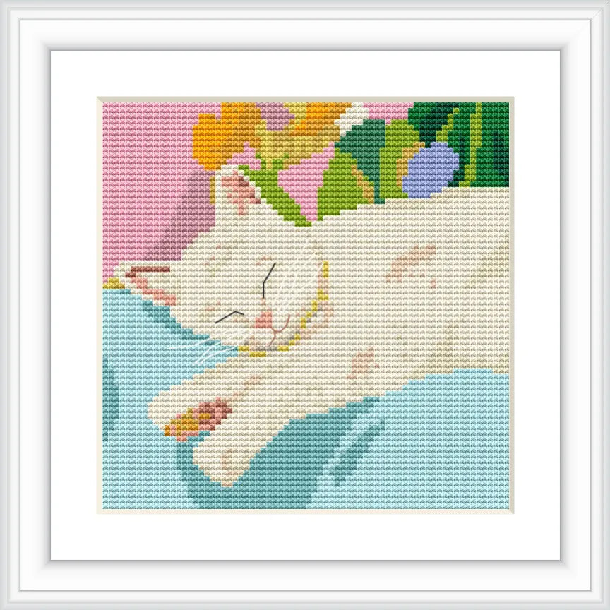 A white cat is sleeping on a light blue cushion. In the background, there are colorful flowers and greenery, creating a peaceful and natural atmosphere.