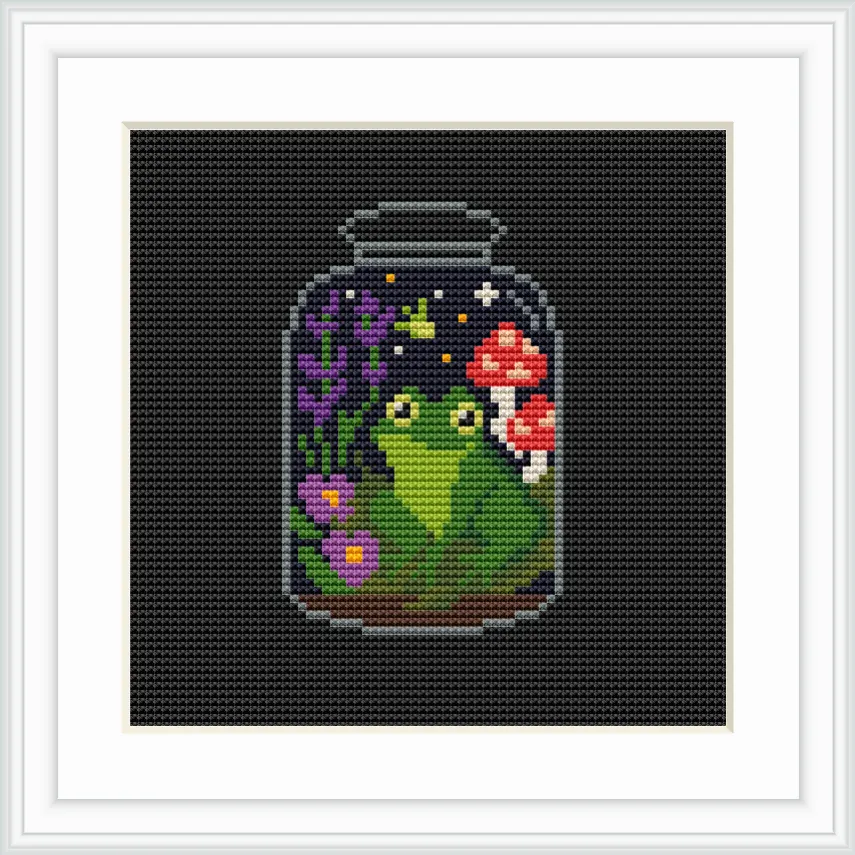 The image shows a jar containing a green frog sitting on leaves, surrounded by purple flowers and red mushrooms. There are tiny stars and sparkles in the background, creating a magical atmosphere.