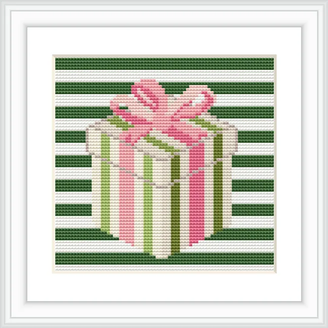 The image features a cross stitch pattern of a gift box with a pink bow and green and white striped wrapping paper. The background consists of horizontal green and white stripes.