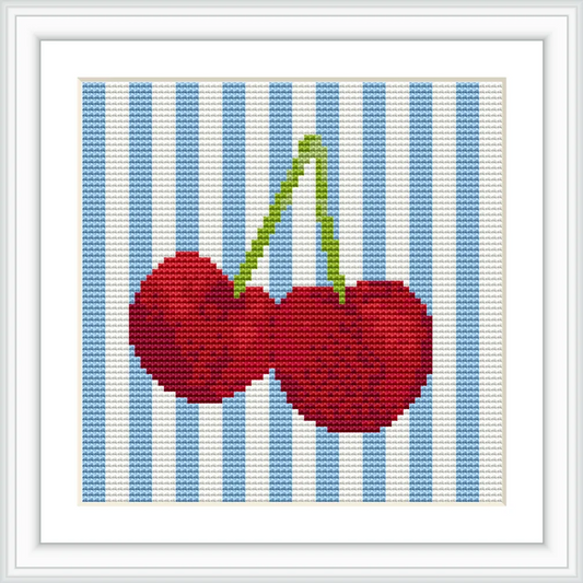 The image features two cherries with green stems against a background of vertical blue and white stripes, framed in a white border.