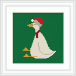 The image depicts a white goose wearing a red Santa hat and a matching red scarf, sitting against a solid green background. The goose's beak and feet are a bright orange.