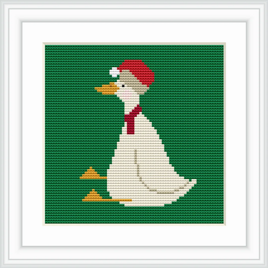 The image depicts a white goose wearing a red Santa hat and a matching red scarf, sitting against a solid green background. The goose's beak and feet are a bright orange.