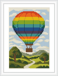 The image shows a large, rainbow-colored hot air balloon floating above a green landscape with a winding path and trees under a blue sky scattered with clouds.