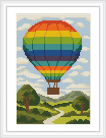 The image shows a large, rainbow-colored hot air balloon floating above a green landscape with a winding path and trees under a blue sky scattered with clouds.