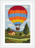 A vibrant hot air balloon with red, orange, and blue stripes floats over a pastoral landscape. Below, a yellow house with a red roof sits among trees and flower-dotted fields under a blue sky with fluffy clouds.