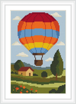 A vibrant hot air balloon with red, orange, and blue stripes floats over a pastoral landscape. Below, a yellow house with a red roof sits among trees and flower-dotted fields under a blue sky with fluffy clouds.