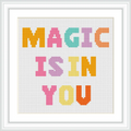 The image features a cross stitch pattern with the words 'MAGIC IS IN YOU' in large, colorful block letters framed with a white border. Each word is in a different color and centered on a white background.