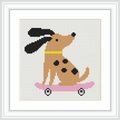 The scene depicts a cartoon-style brown dog with black ears and spots riding a pink skateboard. The dog is centered within a white, framed cross-stitch pattern.