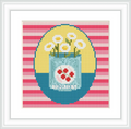 The image depicts a cross stitch design of white flowers standing inside a blue jar labeled 'Tomatoes'. The jar is set against a colorful striped pink and red background with circular yellow and blue sections.