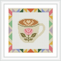A coffee cup with a rose design and frothy heart is at the center, surrounded by a colorful triangular patterned border.