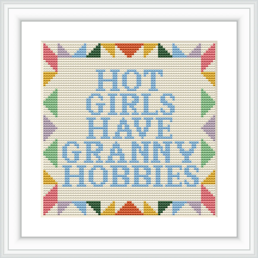 The image features a text-based cross stitch design with the phrase 'Hot Girls Have Granny Hobbies' surrounded by a colorful geometric border. The colors used are pastel shades, and the design is centered on a neutral background.
