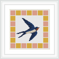The image shows a cross stitch of a blue swallow with a white underbelly and red throat in flight, surrounded by a geometric border of squares in yellow and peach.