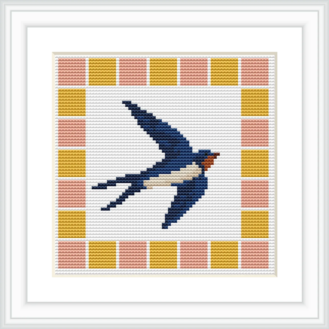The image shows a cross stitch of a blue swallow with a white underbelly and red throat in flight, surrounded by a geometric border of squares in yellow and peach.