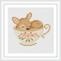 A small fawn is sleeping inside a decorative teacup with flowers painted on it. The teacup is placed centrally within the pattern, creating a cozy and charming scene.