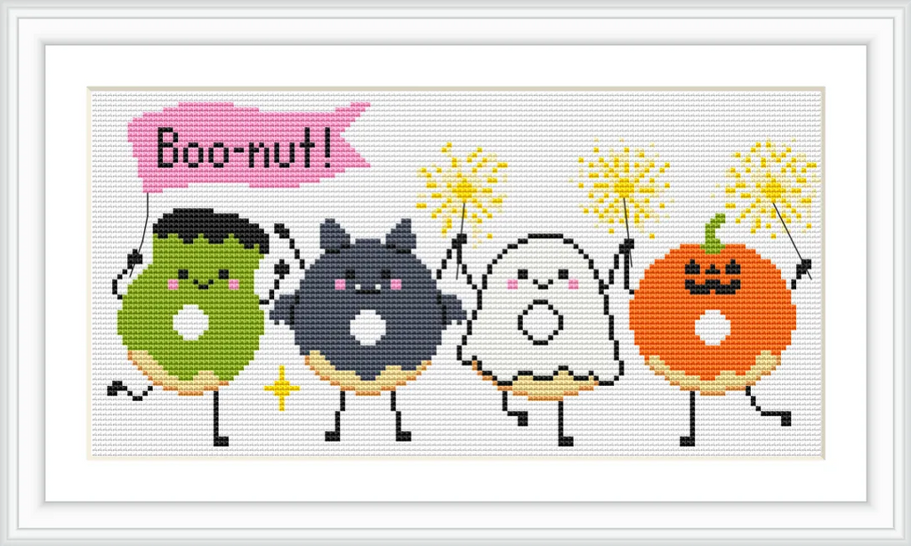 Four cartoon-style donuts, each with a different Halloween-themed character: a green Frankenstein, a black cat, a white ghost, and an orange pumpkin, each holding sparklers. The word 'Boo-nut!' is written above them in a pink speech bubble.