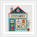 This image features a craft shop with the word 'STITCHERY' at the top. The shop has a teal roof, a door with a hanging sign, four window panels, and a potted plant on the side.