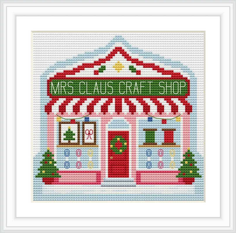 The image depicts a quaint craft shop with a red and white striped awning. The sign reads 'Mrs Claus Craft Shop'. There are two Christmas trees flanking the entrance, which is adorned with a wreath. The shop windows display holiday-themed items like a Christmas tree and colored ribbons.